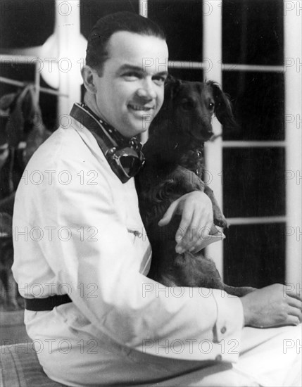 Racing driver Rudolph Caracciola with his pet dog. Creator: Unknown.