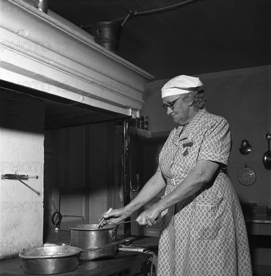 Housewife at the fireplace, Abonas, Sweden, 1956. Creator: Unknown.