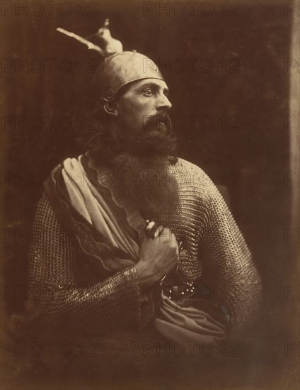 The Passing of King Arthur, 1874. A melodramatic depiction of Arthur?s death scene.  A bearded man (William Warder) in profile, wearing chainmail and an armour helmet with his right hand gripping a sword. A photographic illustration to Alfred Tennyson's "Idylls of the King"; a series of narrative poems based on the legends of King Arthur.
