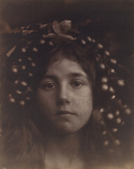 Circe, 1865. A child (Kate Keown) with grapes and leaves around her head, in close-up and slightly out of focus, with the subject looking straight into the camera. Circe is an ancient Greek enchantress who appears in Homer?s Odyssey. Cameron inscribed the mount of this photograph with a quotation from Milton: ?Who knows not Circe / daughter of the Sun?.