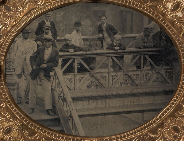Group of Men and Boys Standing Along the Railing of the Fulton Street Bridge, 1866-68.