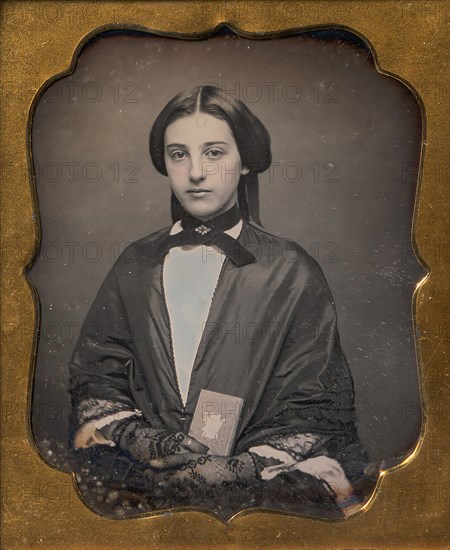 Young Woman Wearing Lace Gloves Holding a Daguerreotype Case, 1860s.