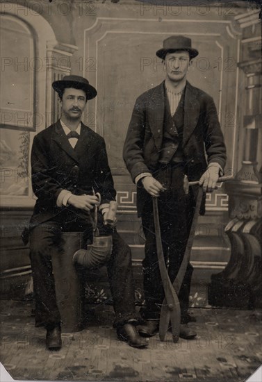 Two Stovepipe Makers, One with a Hammer and Tin Snips, the Other Sitting on Stovepipe Assembly with Tin Snips and Mallet, 1880s.