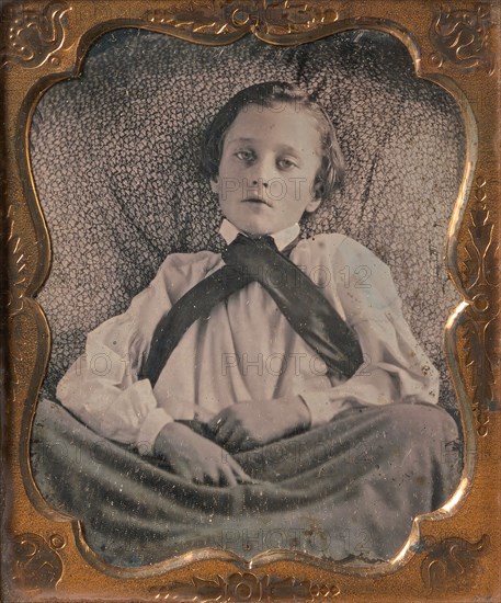 Boy Seated Cross-legged, Partially Covered by Blanket, Leaning Against Cushion, 1850s.