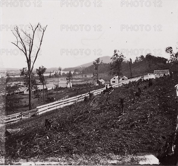 [White picket fence with buildings in background]. Brady album, p. 123, 1861-65. Formerly attributed to Mathew B. Brady.