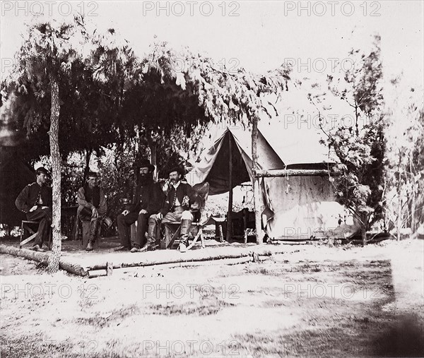 [Four men in camp under a lean-to of pine boughs], 1861-65. Formerly attributed to Mathew B. Brady.