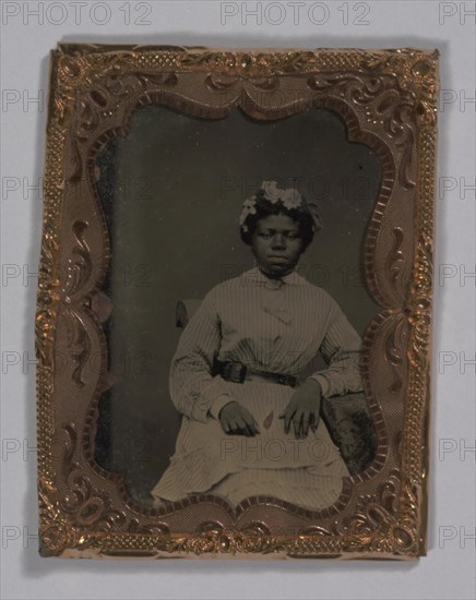 Tintype of a woman wearing a striped dress with flowers in her hair, 1855-1860s. Creator: Unknown.