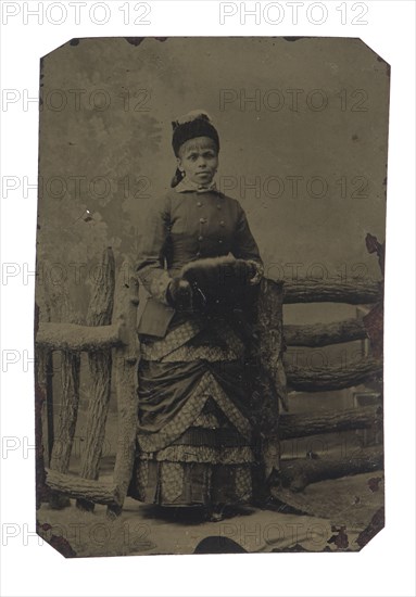 Tintype of woman in jacket and dress with hat and muff, 1880s. Creator: Unknown.