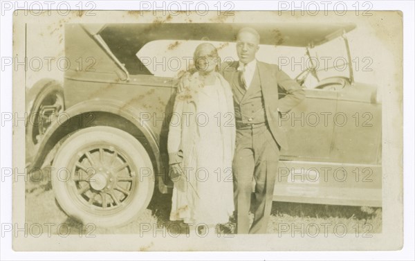 Photograph of a man and woman in front of car, ca. 1921. Creator: Unknown.