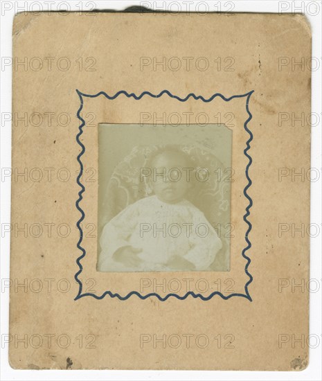 Photograph of a baby dressed in white and sitting in a chair, ca. 1870. Creator: Unknown.