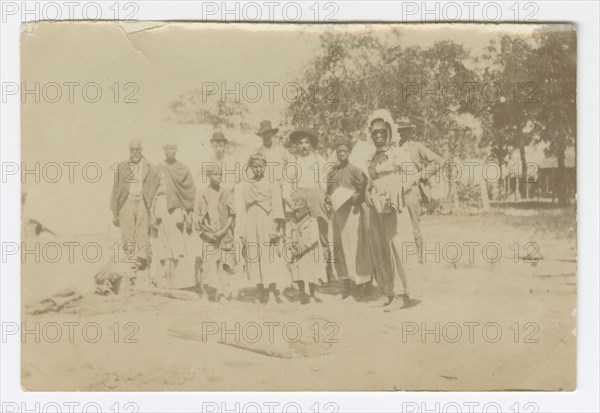 Photograph of men, women, and children in a yard, early 20th century. Creator: Unknown.