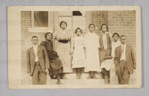 Photographic print of 8 people in front of a building, 1904-1918. Creator: Unknown.