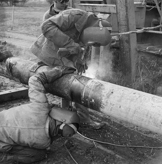Two welders at work on the Mersey oil pipeline, 24/09/1967. Creator: John Laing plc.