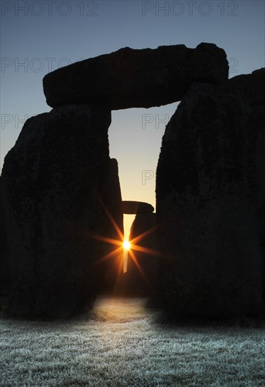 View of Stonehenge, showing the sun's rays glinting through the opening in a trilithon, 2012. Creator: James O Davies.