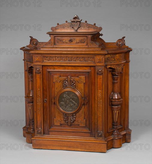 Cabinet, 1875/77. Greek key pattern, turned and carved wood, bronze plaque depicting shepherd, shepherdess and sheep.