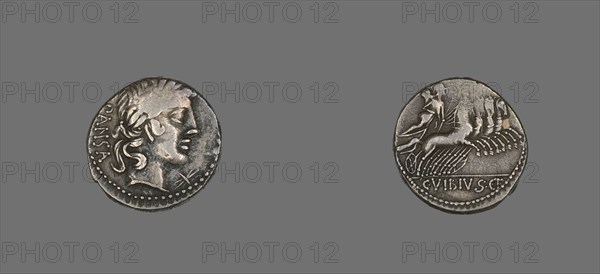 Denarius (Coin) Depicting the God Apollo, 90 BCE. Silver coin with a face in profile on one side, a figure riding a chariot pulled by four horses on the reverse.