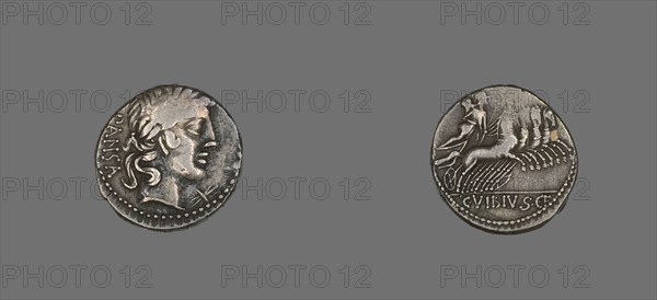 Denarius (Coin) Depicting the God Apollo, 90 BCE. Silver coin with a face in profile on one side, a figure riding a chariot pulled by four horses on the reverse.