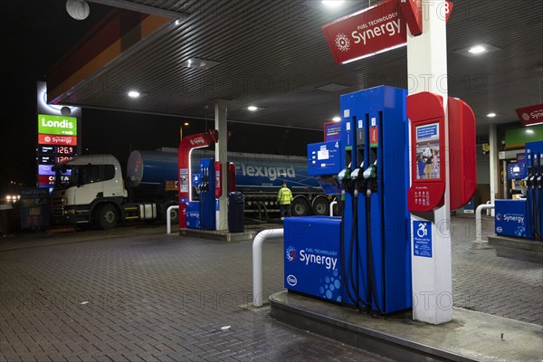 Esso petrol station forecourt with tanker delivering fuel, 2020.