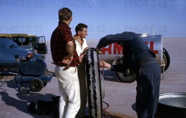 Mechanics inflating Bluebird CN7 tyre for World Land Speed Record attempt, Lake Eyre, 1964. Creator: Unknown.