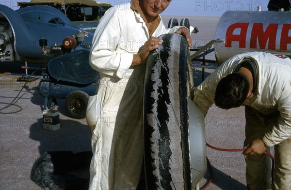 Mechanics inflating Bluebird CN7 tyre for World Land Speed Record attempt, Lake Eyre, 1964. Creator: Unknown.