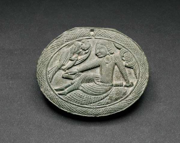 Oval Cosmetic Box Lid with a Man Being Entertained by a Lyrist, 5th/6th century. Ancient region of Gandhara (modern Pakistan).