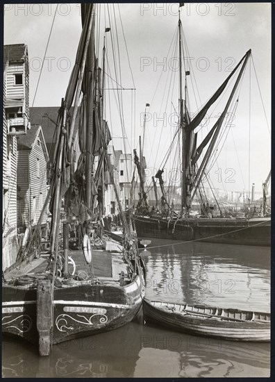 Sailed fishing vessels moored beside timber warehouses at Rochester, Medway, 1925-1935. Creator: J Dixon Scott.