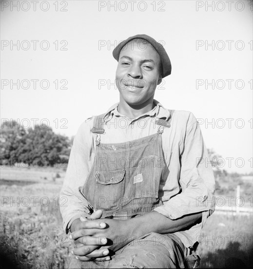 Plough boy sitting on fence after a day's work, Eutaw, Alabama, 1936. Creator: Dorothea Lange.