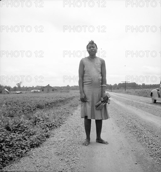 Negro woman carrying her shoes home from church, Mississippi Delta, 1936. Creator: Dorothea Lange.