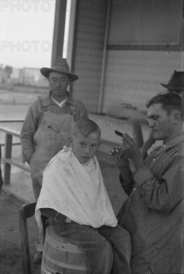 Community barber shop in Kern County migrant camp, California, 1936. Creator: Dorothea Lange.