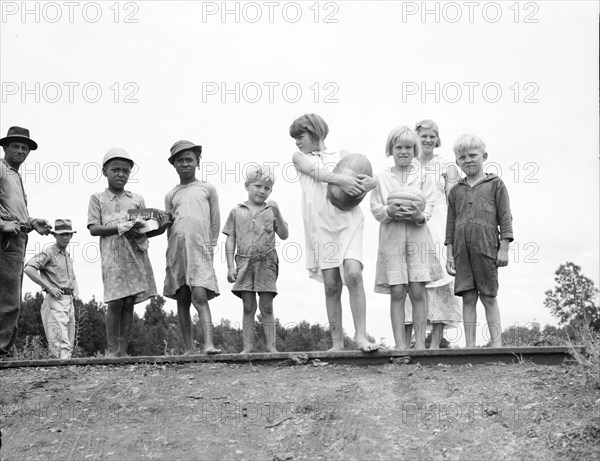 Sharecroppers' families gathering needs for their 4th of July celebration..., Mississippi, 1936. Creator: Dorothea Lange.