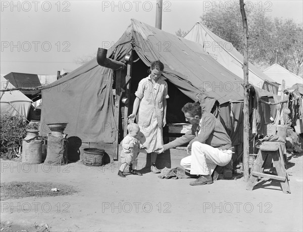 Tom Collins, manager of Kern migrant camp, with drought refugee family, California, 1936. Creator: Dorothea Lange.