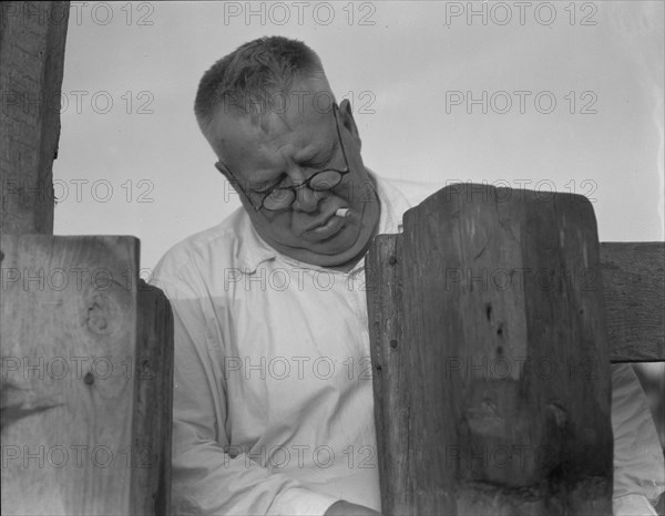 Henry Lotz closing the gate to the barns at the Midway City Dairy Association, near Santa Ana, 1937. Creator: Dorothea Lange.