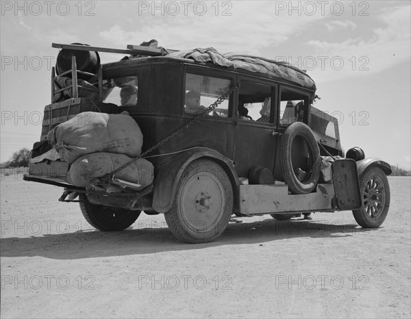 Family...from Fort Smith, Arkansas, trying to repair their car..., Arizona, 1937. Creator: Dorothea Lange.