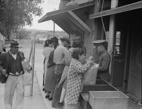 Plant quarantine inspectors examining packages brought over the bridge..., Texas, 1937. Creator: Dorothea Lange.