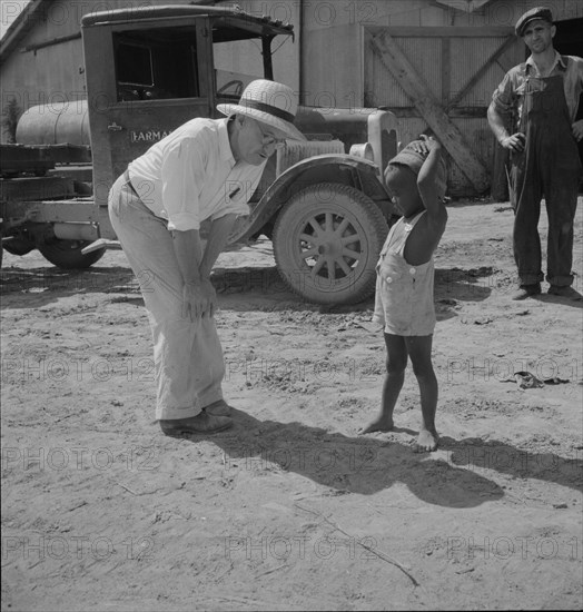 Plantation owner with one of the Negro plantation children, Aldridge Plantation, Mississippi, 1937. Creator: Dorothea Lange.