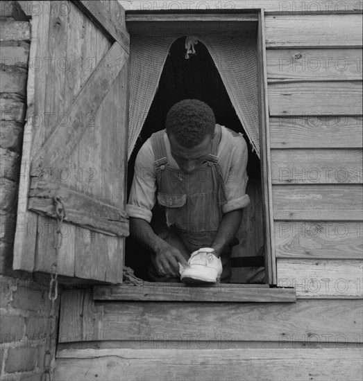 Negro field hand getting ready to go to town on a Saturday afternoon, 1937. Creator: Dorothea Lange.