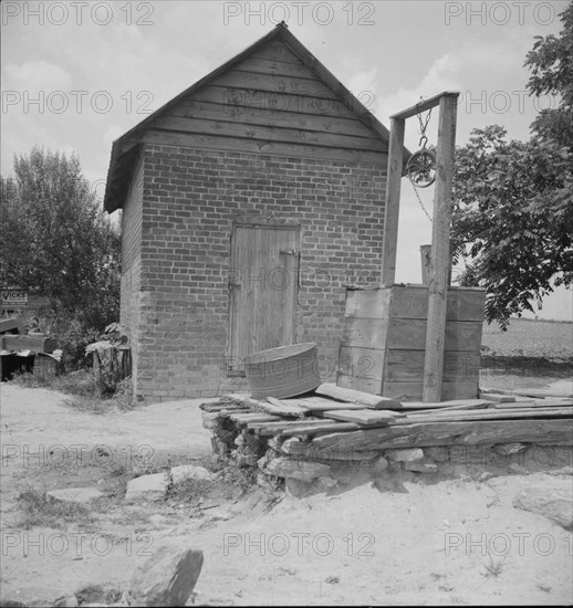 Well and old plantation smokehouse, Chesnee, South Carolina, 1937. Creator: Dorothea Lange.