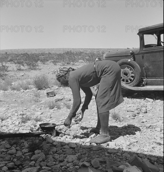 Young Negro wife cooking breakfast, outskirts of El Paso, Texas, 1938. Creator: Dorothea Lange.