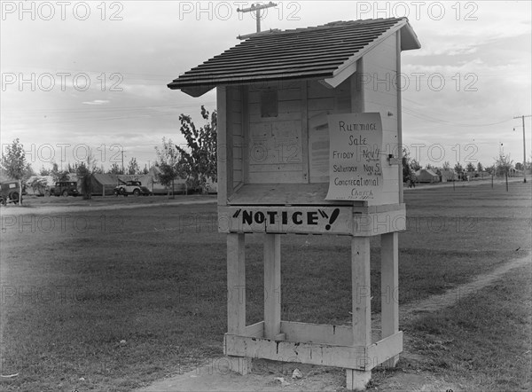 Campers' bulletin board near entrance of Shafter camp for migrant workers, California, 1938. Creator: Dorothea Lange.