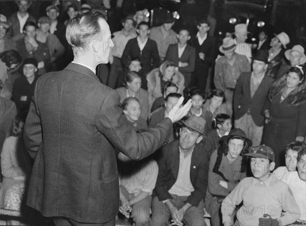 Street meeting at night in Mexican town outside of Shafter, California, 1938. Creator: Dorothea Lange.