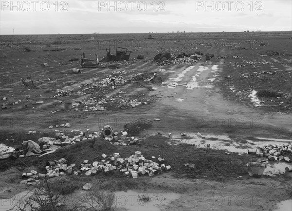 Debris left out on the flats where squatters' camp stood during work season, Kern County, 1939. Creator: Dorothea Lange.