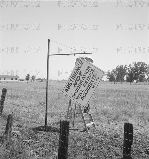 Member of the committee...erects sign on the highway, U.S. 99, near Hanford, CA, 1939. Creator: Dorothea Lange.
