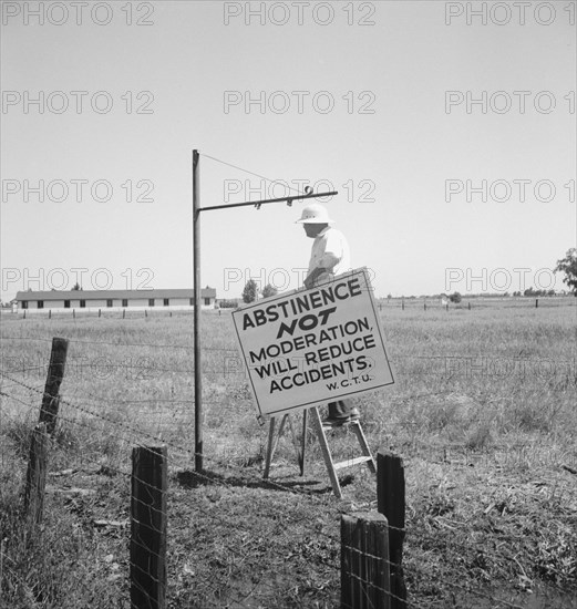 Member of the committee...erects sign on U.S. 99 highway, near Hanford, California, 1939. Creator: Dorothea Lange.