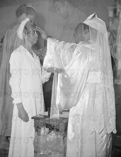 Mrs. Ella Watson, a government charwoman, receiving annointment..., Washington, D.C., 1942. Creator: Gordon Parks.