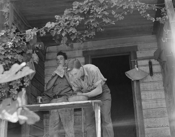 Hop farmer's sons, washing for noon meal on back porch, Independence, Polk County, Oregon, 1939. Creator: Dorothea Lange.