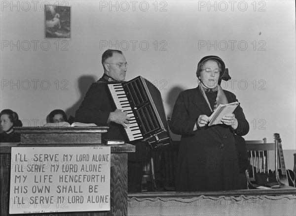 Adjutant and his wife sing, Salvation Army, San Francisco, California, 1939. Creator: Dorothea Lange.