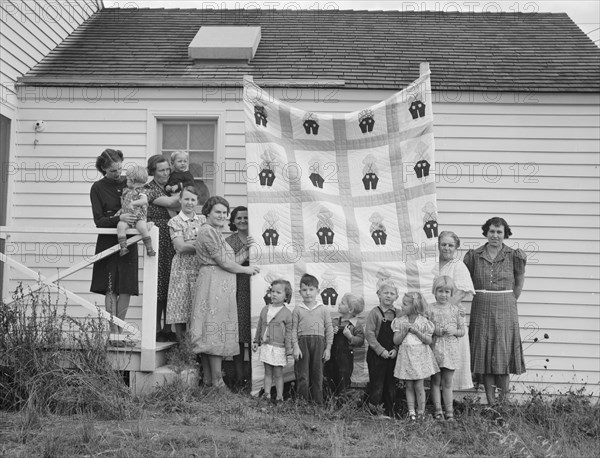 Farm women of the "Helping Hand" club display a pieced quilt..., near West Carlton, Oregon, 1939. Creator: Dorothea Lange.