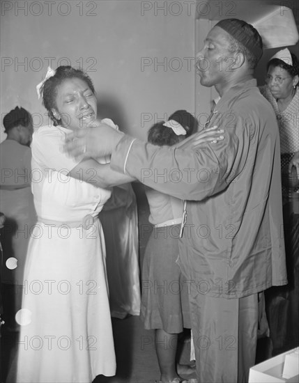 A member of the St. Martin's Spiritual Church, receiving the final..., Washington, D.C., 1942. Creator: Gordon Parks.