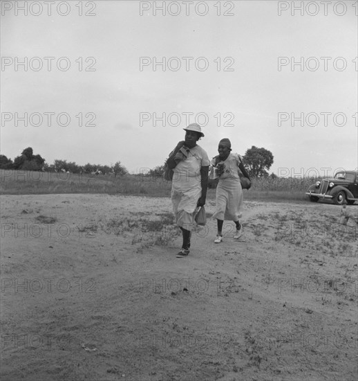 Mother of sharecropper family and friend...in the rain, Person County, North Carolina, 1939. Creator: Dorothea Lange.