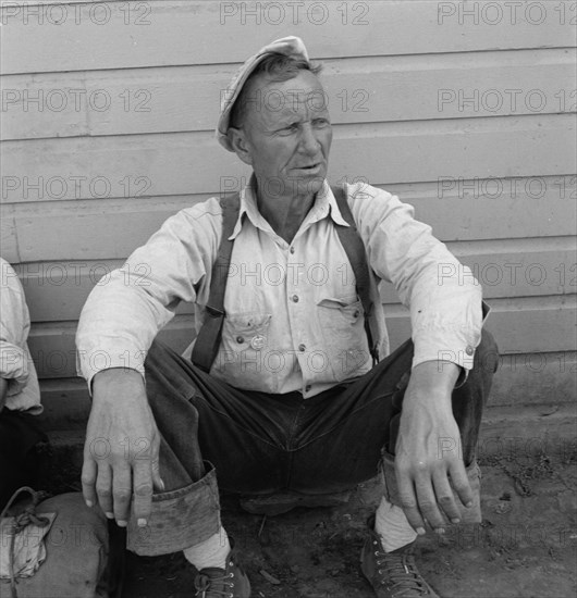 Bindle stiff, used to be logger, Side of Pastime Café, Tulelake, Siskiyou County, California, 1939. Creator: Dorothea Lange.